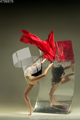 Image of Young and stylish modern ballet dancer on brown background