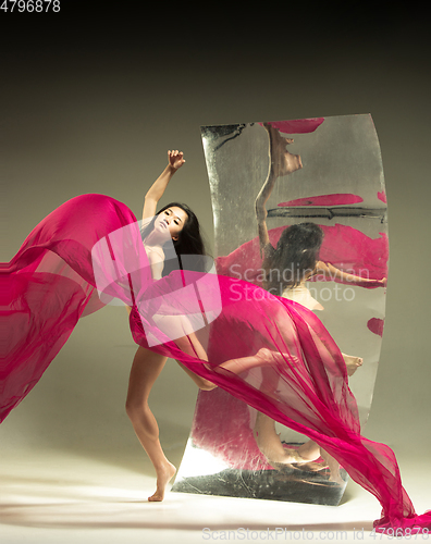 Image of Young and stylish modern ballet dancer on brown background