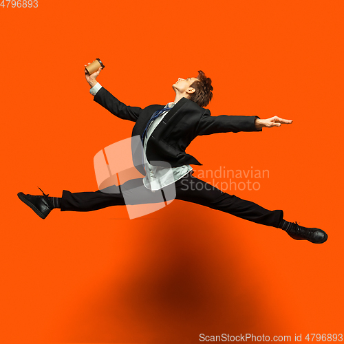 Image of Man in casual office style clothes jumping isolated on studio background