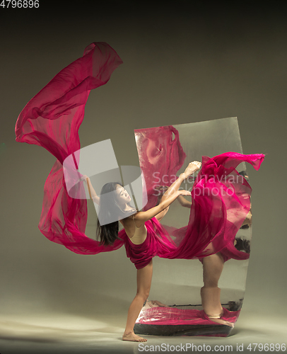 Image of Young and stylish modern ballet dancer on brown background