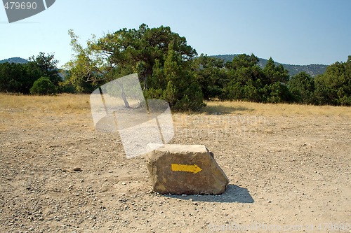 Image of Arrow on a stone, specifying a direction in mountains