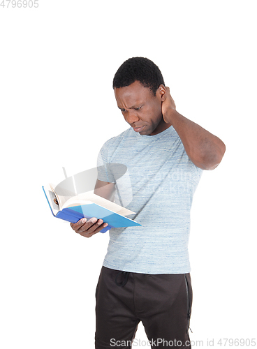 Image of Puzzled African man looking at his book