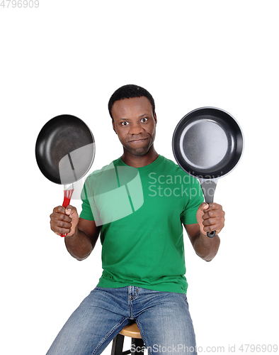 Image of African American man holding up two freeing pan