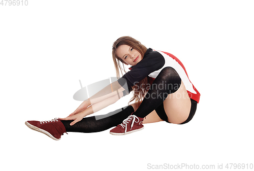 Image of Young woman stretching on the floor