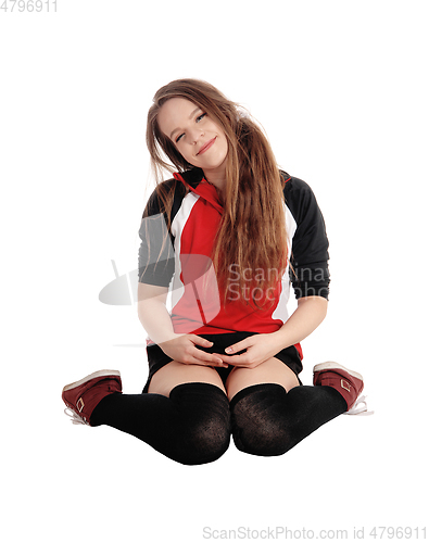 Image of Young woman sitting  on the floor, smiling