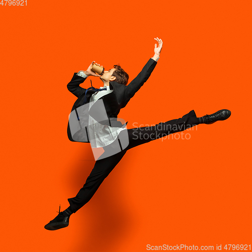 Image of Man in casual office style clothes jumping isolated on studio background