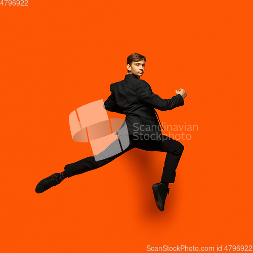 Image of Man in casual office style clothes jumping isolated on studio background