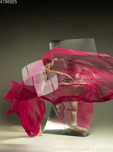 Image of Young and stylish modern ballet dancer on brown background