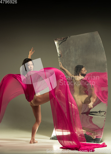 Image of Young and stylish modern ballet dancer on brown background