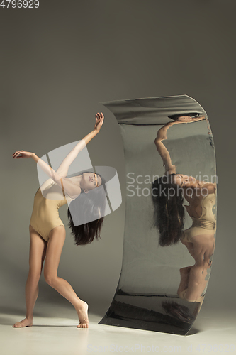 Image of Young and stylish modern ballet dancer on brown background