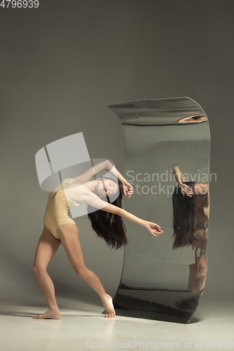 Image of Young and stylish modern ballet dancer on brown background