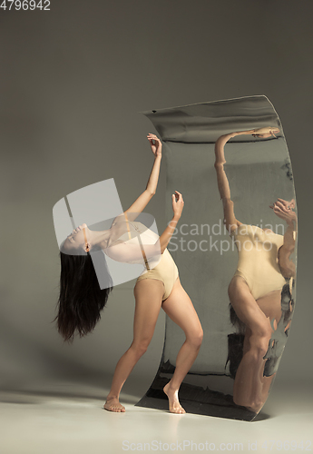 Image of Young and stylish modern ballet dancer on brown background