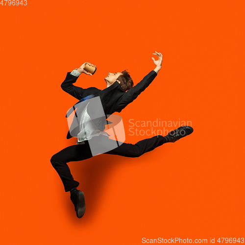 Image of Man in casual office style clothes jumping isolated on studio background