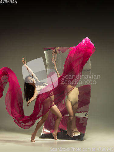 Image of Young and stylish modern ballet dancer on brown background