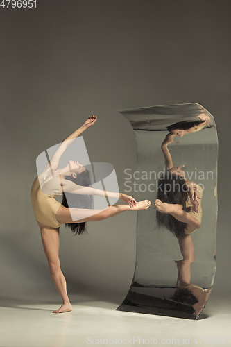 Image of Young and stylish modern ballet dancer on brown background