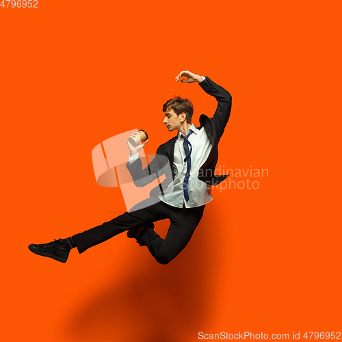 Image of Man in casual office style clothes jumping isolated on studio background