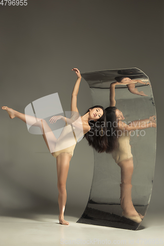 Image of Young and stylish modern ballet dancer on brown background