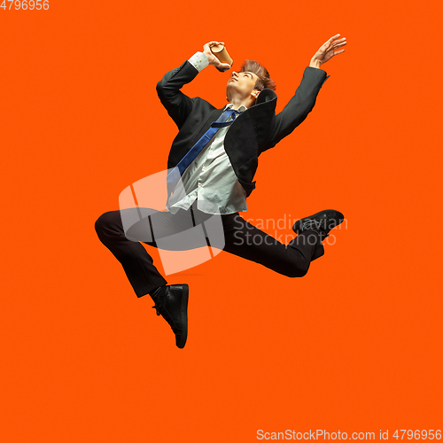 Image of Man in casual office style clothes jumping isolated on studio background