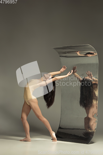 Image of Young and stylish modern ballet dancer on brown background