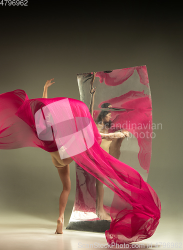 Image of Young and stylish modern ballet dancer on brown background