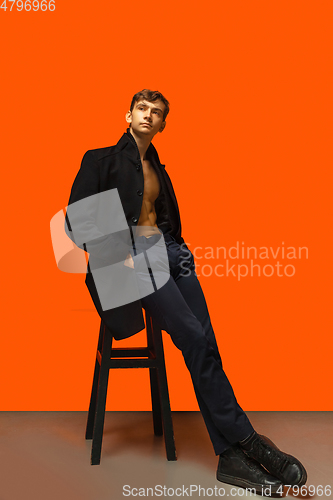 Image of Portrait of a handsome young man on orange background