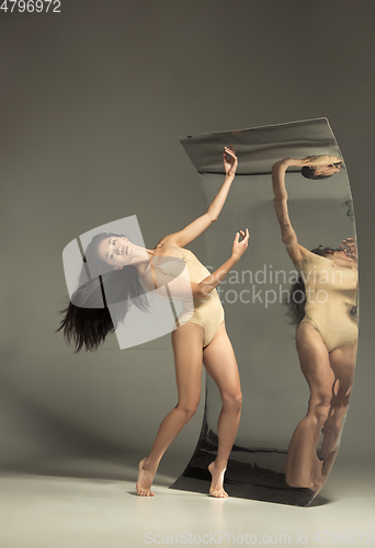 Image of Young and stylish modern ballet dancer on brown background