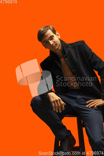 Image of Portrait of a handsome young man on orange background