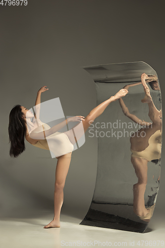 Image of Young and stylish modern ballet dancer on brown background