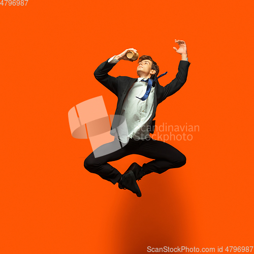 Image of Man in casual office style clothes jumping isolated on studio background