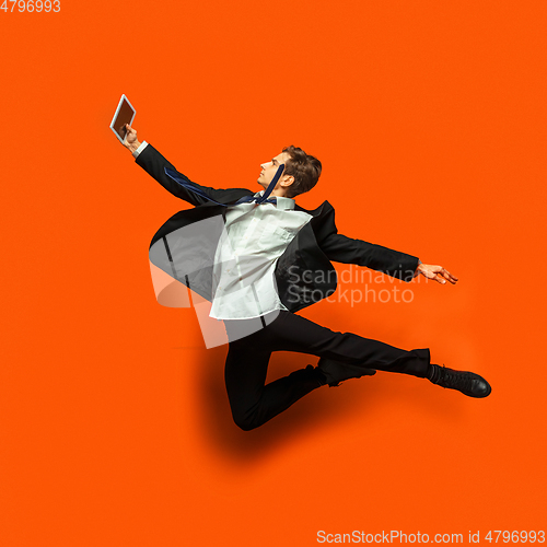 Image of Man in casual office style clothes jumping isolated on studio background