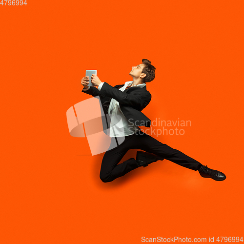 Image of Man in casual office style clothes jumping isolated on studio background