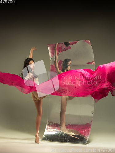 Image of Young and stylish modern ballet dancer on brown background