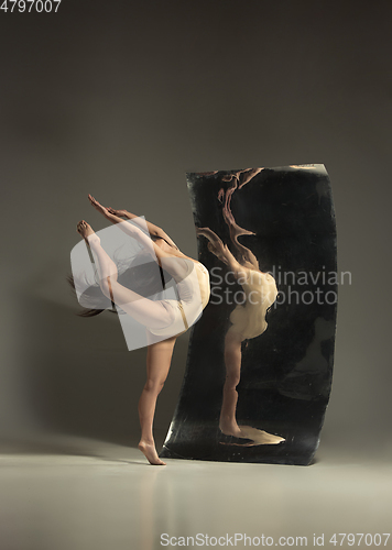 Image of Young and stylish modern ballet dancer on brown background