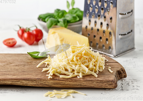 Image of grated cheese on wooden cutting board