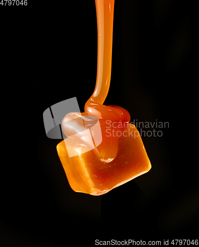 Image of caramel sauce flowing on flying caramel candy