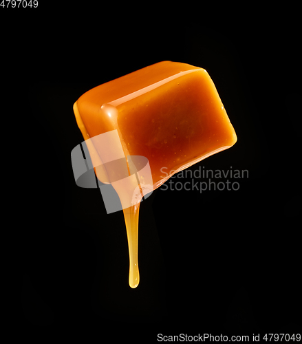 Image of caramel sauce flowing on flying caramel candy