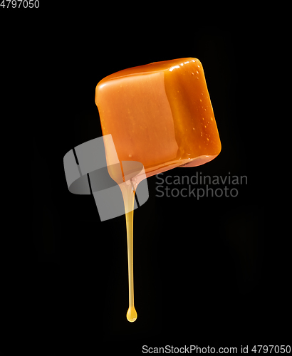 Image of caramel sauce flowing on flying caramel candy