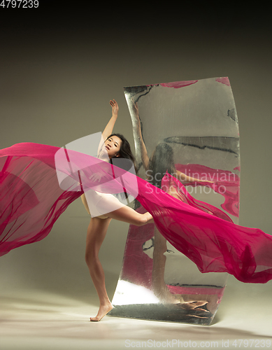 Image of Young and stylish modern ballet dancer on brown background