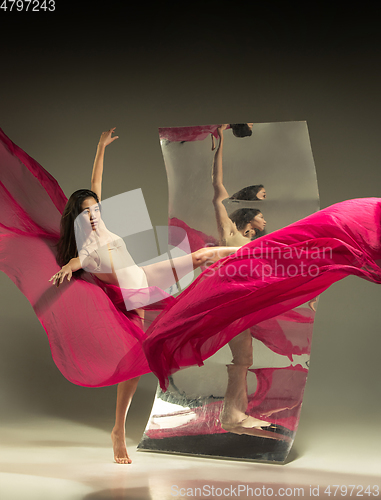 Image of Young and stylish modern ballet dancer on brown background