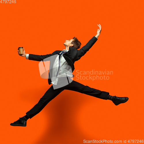 Image of Man in casual office style clothes jumping isolated on studio background