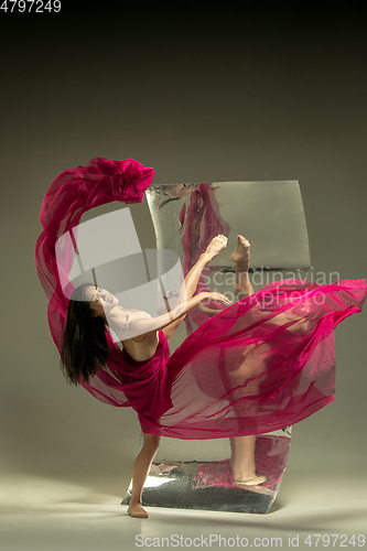 Image of Young and stylish modern ballet dancer on brown background