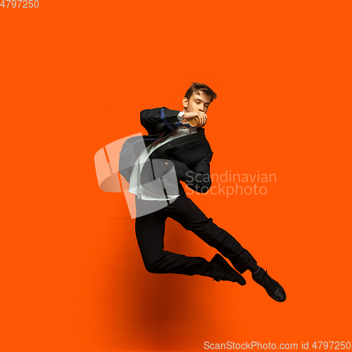 Image of Man in casual office style clothes jumping isolated on studio background