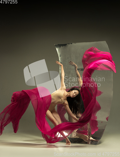 Image of Young and stylish modern ballet dancer on brown background