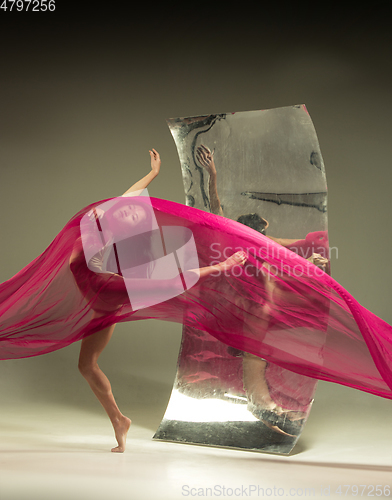 Image of Young and stylish modern ballet dancer on brown background