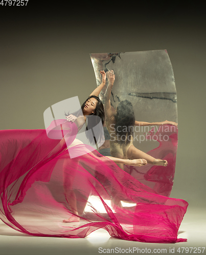 Image of Young and stylish modern ballet dancer on brown background