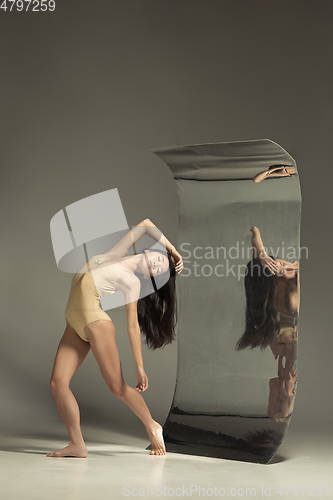 Image of Young and stylish modern ballet dancer on brown background