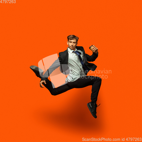 Image of Man in casual office style clothes jumping isolated on studio background