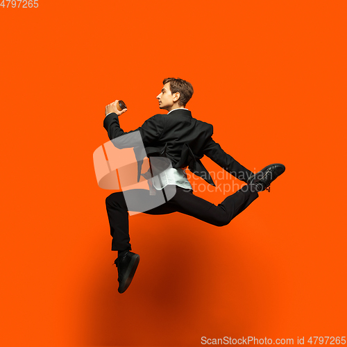 Image of Man in casual office style clothes jumping isolated on studio background