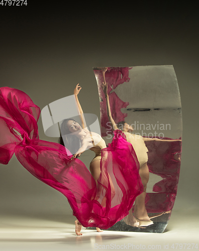 Image of Young and stylish modern ballet dancer on brown background