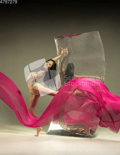 Image of Young and stylish modern ballet dancer on brown background